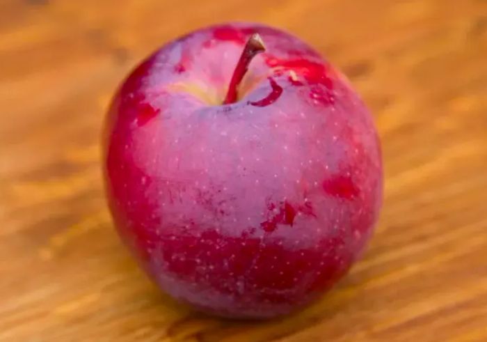 An Empire apple resting on a wooden surface