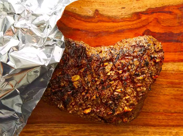 A grilled tri-tip resting on a cutting board, ready to be sliced.