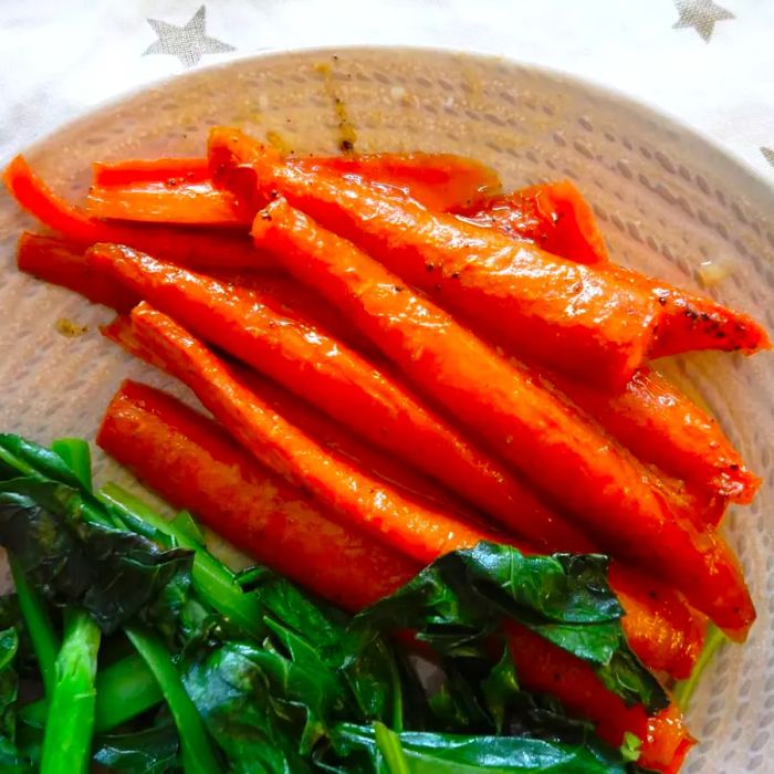 Honey roasted carrots arranged on a plate with fresh greens.