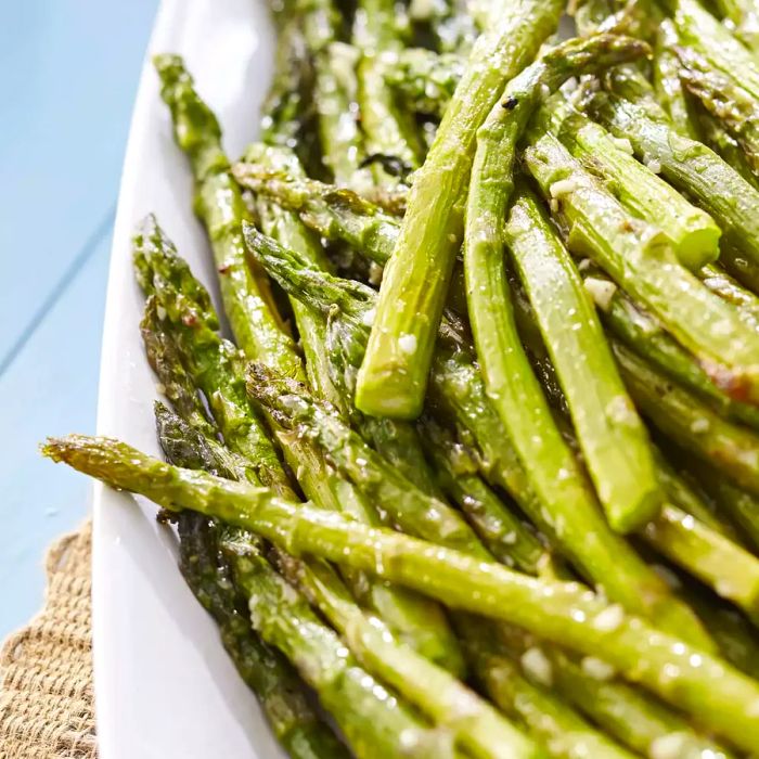 Oven-roasted asparagus served in a white bowl.