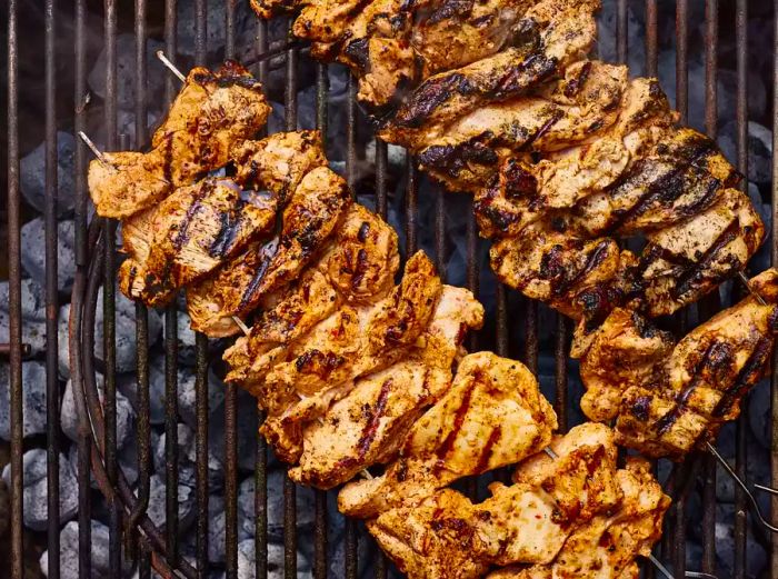 Aerial shot of Turkish Chicken Kebabs sizzling on a charcoal grill.