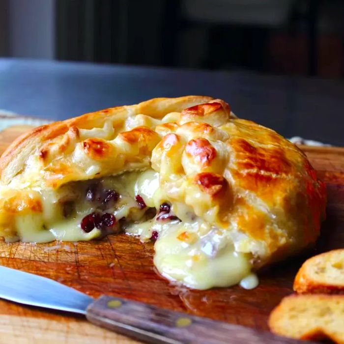 A delicious cranberry and brie pastry appetizer displayed on a cheese board.