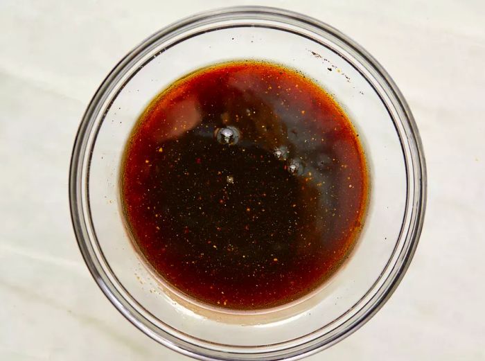 A top-down view of a kebab marinade in a glass bowl.