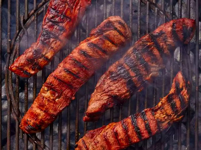 Char siu cooking on the grill, nearly ready to serve.