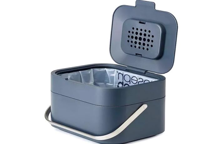 A charcoal gray Joseph Joseph compost bin with an open lid