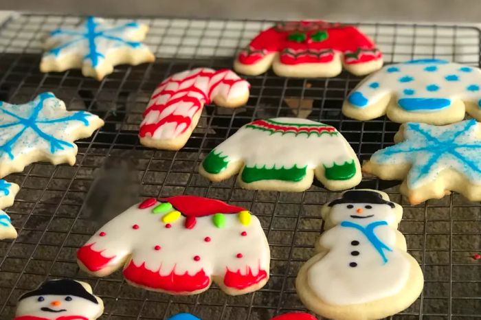 Sugar cookies in the shapes of Christmas sweaters, snowmen, candy canes, and snowflakes