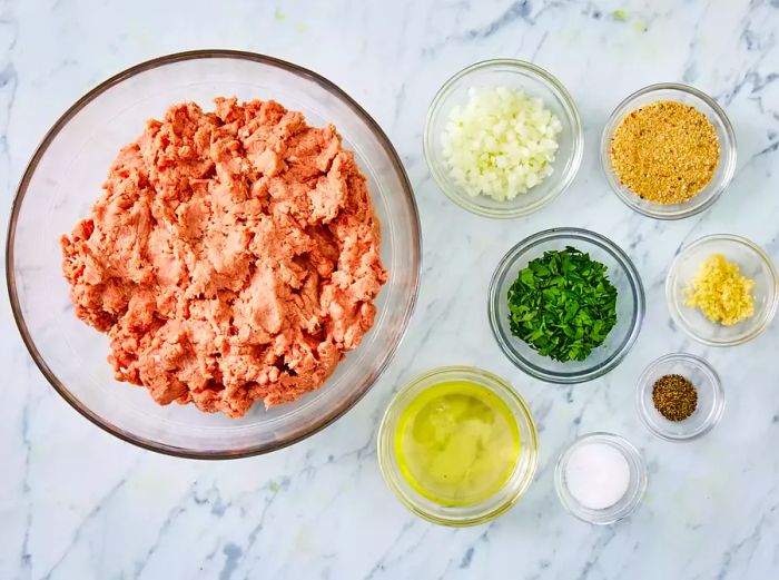 A top-down view of the turkey burger ingredients neatly arranged in separate bowls.