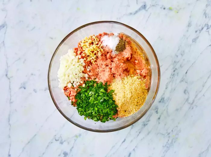 A top-down view of turkey burger ingredients, still unmixed in a bowl.