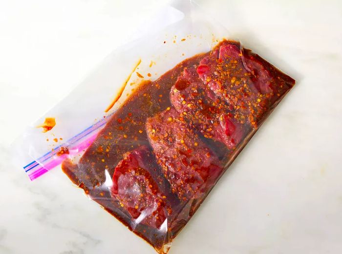 Aerial view of venison steaks marinating in a plastic bag