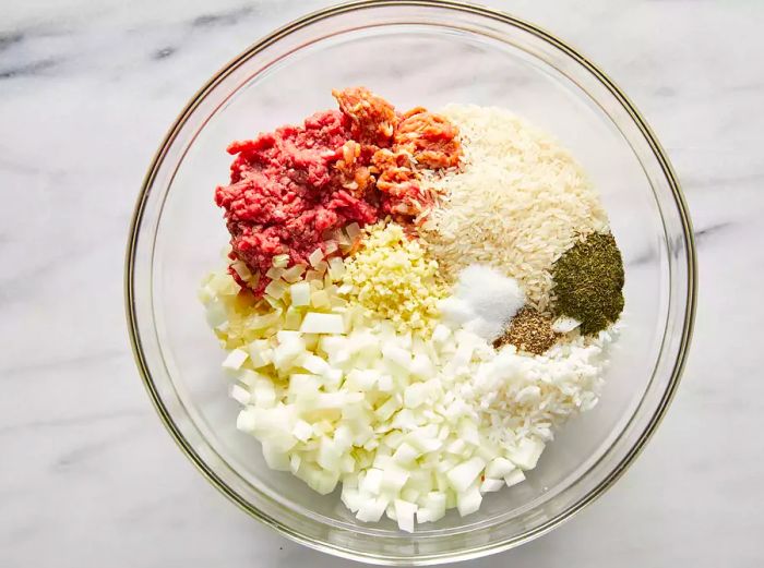 A top-down view of a mixing bowl filled with ingredients for stuffed cabbage rolls.