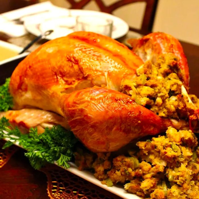 A beautifully brined and roasted turkey served on a platter with stuffing