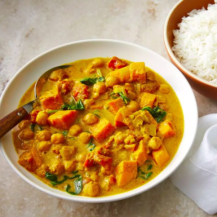 A bowl of Vegan Sweet Potato Chickpea Curry served with a side of rice