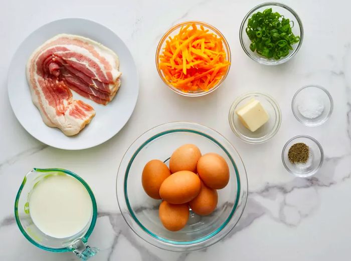 A top-down view of all the ingredients needed for the bacon cheese frittata.