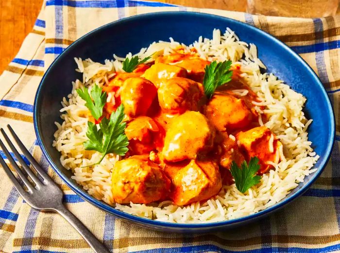 A bowl of Chicken Tikka Masala served over a bed of rice