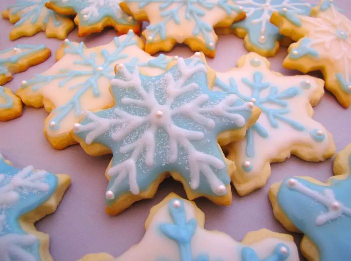 Snowflake-shaped cookies embellished with soft blue and white icing