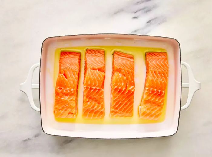 Salmon arranged in a lightly greased baking dish.