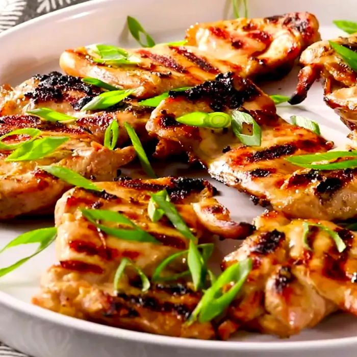 A close-up shot of Vietnamese Grilled Lemongrass Chicken garnished with green onions, served on a platter.