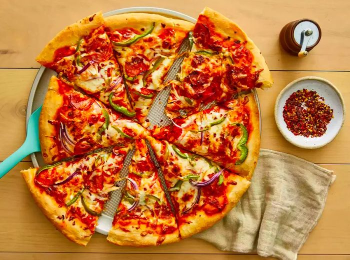 A whole pizza, sliced and resting on a pizza tray, ready to be enjoyed.