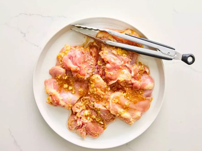 A plate of chicken marinated in lemongrass, ready to be grilled.