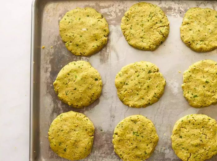 Aerial view of formed chickpea falafel patties laid out on a sheet pan