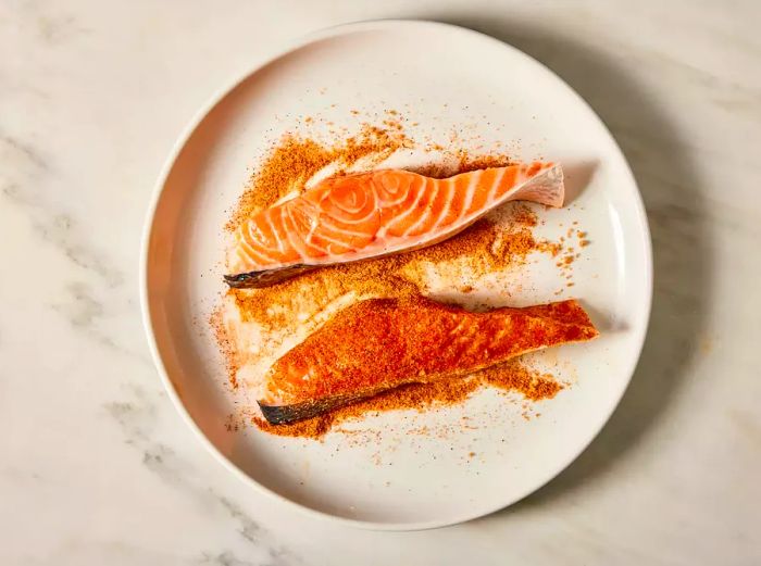 Two salmon fillets generously coated with Cajun seasoning.