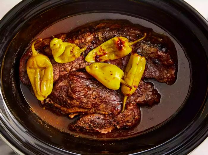 A fully cooked pepperoncini pot roast in the slow cooker.