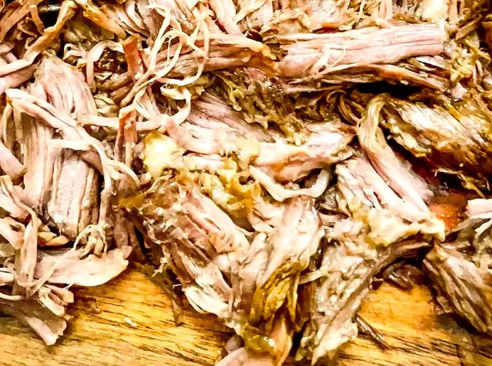 Shredded beef resting on a cutting board