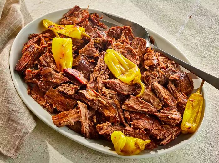 A serving of Mississippi roast (slow cooker pepperoncini pot roast), garnished with pepperoncini peppers.