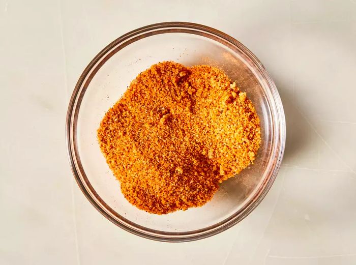 A top-down shot of Cajun seasoning in a small glass bowl.