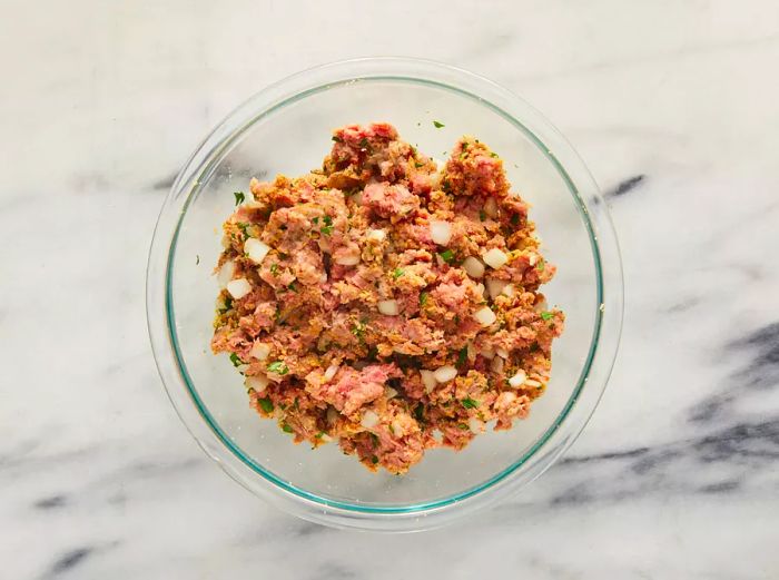 Aerial view of ingredients blended together in a bowl to prepare meatballs