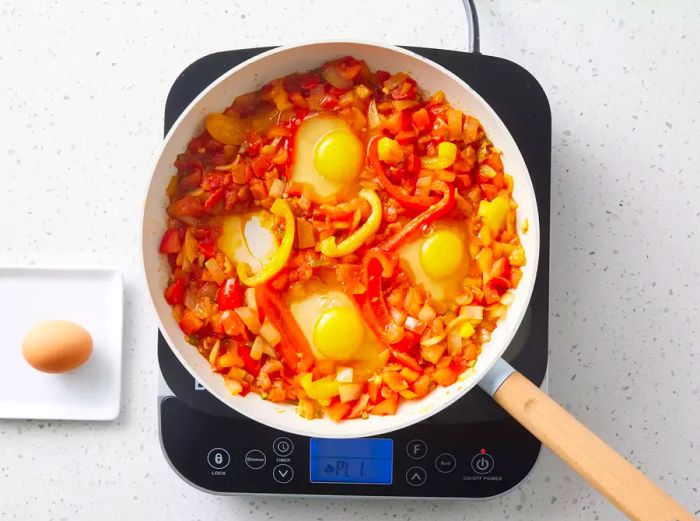 Eggs cracked into the skillet, ready to cook.