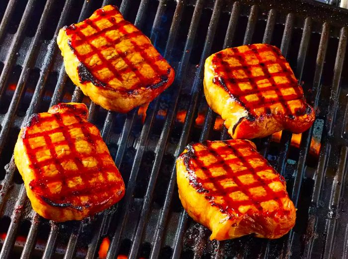 Chinese pork chops grilling on an outdoor barbecue