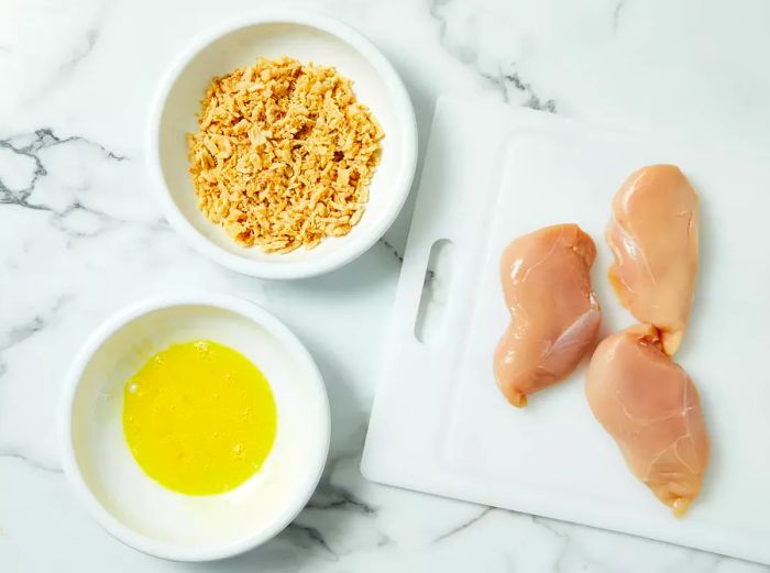 Crushed French onions and beaten egg are set out in separate bowls.