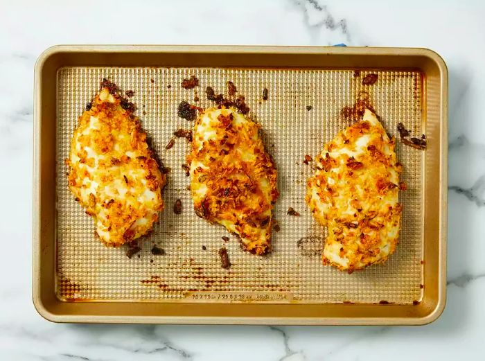 Bake the chicken on a baking sheet until it is golden brown, the juices run clear, and it reaches an internal temperature of 165°F.