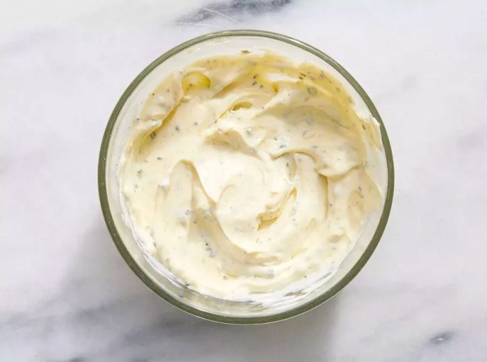 A small glass bowl filled with seasoned mayonnaise