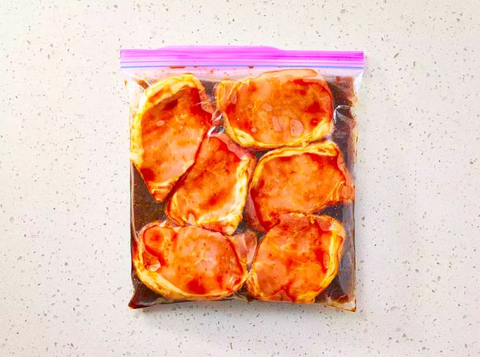 Pork chops and marinade inside a plastic bag