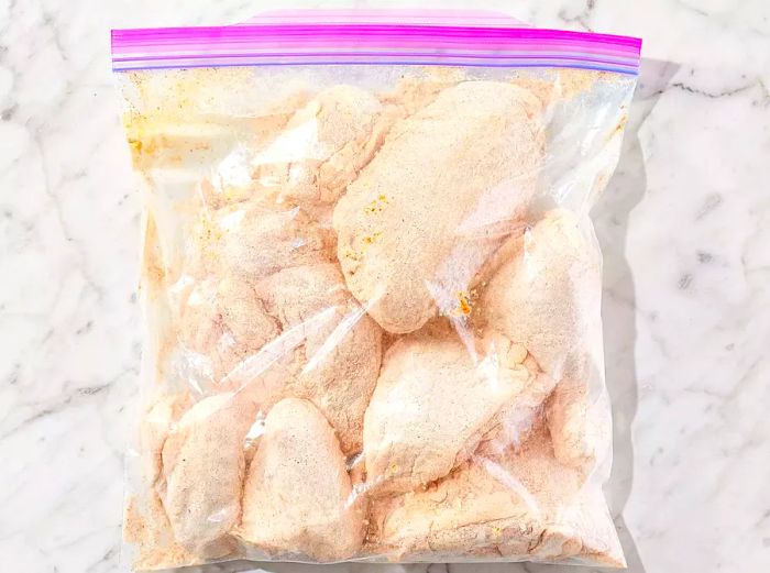 Chicken in a ziplock bag, fully coated with the seasoning blend