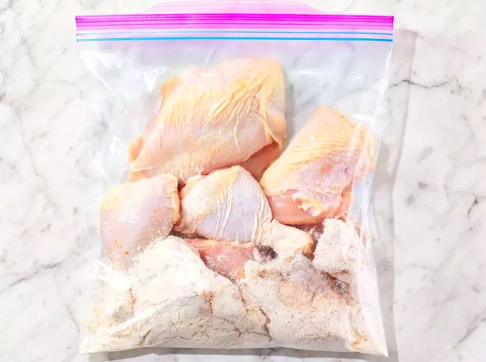 Chicken and seasoning in a ziplock bag, ready to be shaken and coated evenly