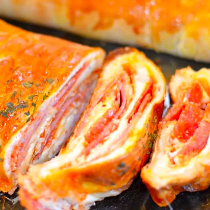 A close-up shot of a sliced Stromboli filled with meat and cheese