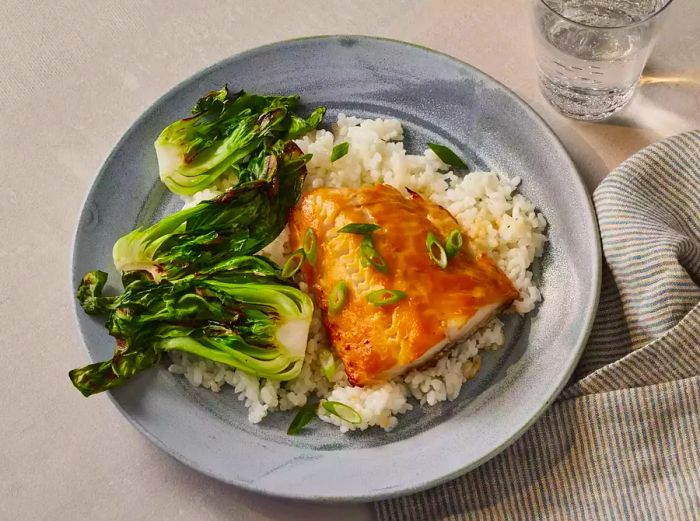 A plate of rice topped with miso-glazed black cod, viewed from above