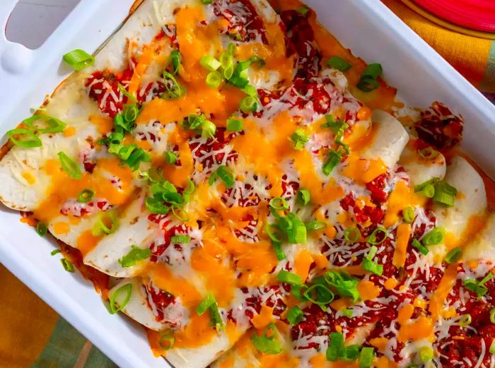 Close-up shot of cheese enchiladas in a white baking dish