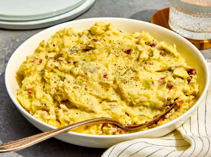 A large serving dish filled with Suzy's creamy mashed red potatoes.