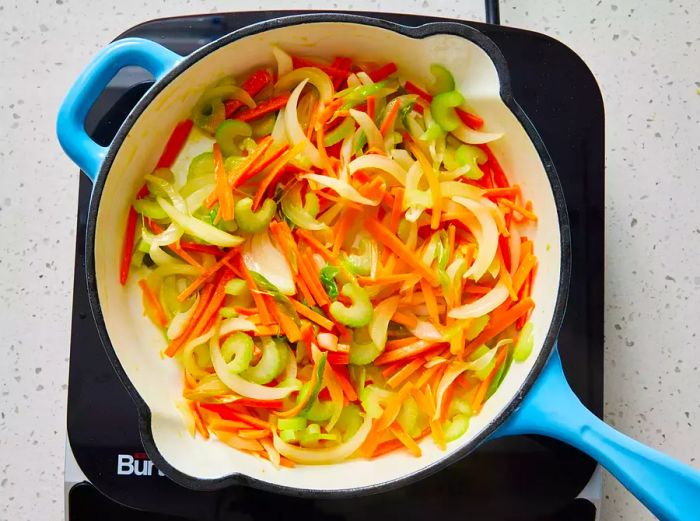 vegetables sautéing in a skillet until they become slightly tender