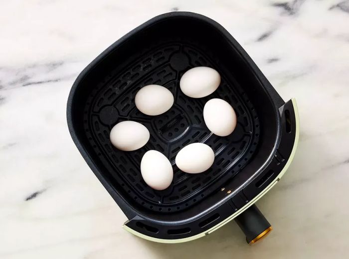 Arrange eggs in the air fryer basket.