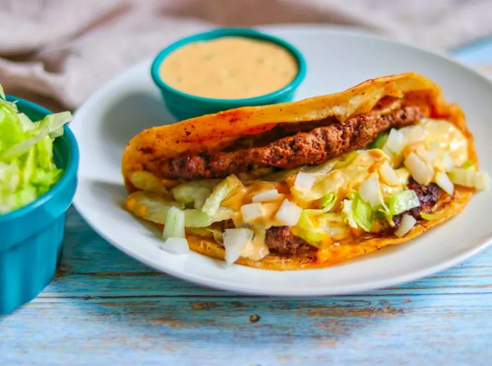 Smash burger tacos with melted cheese and a side of dip