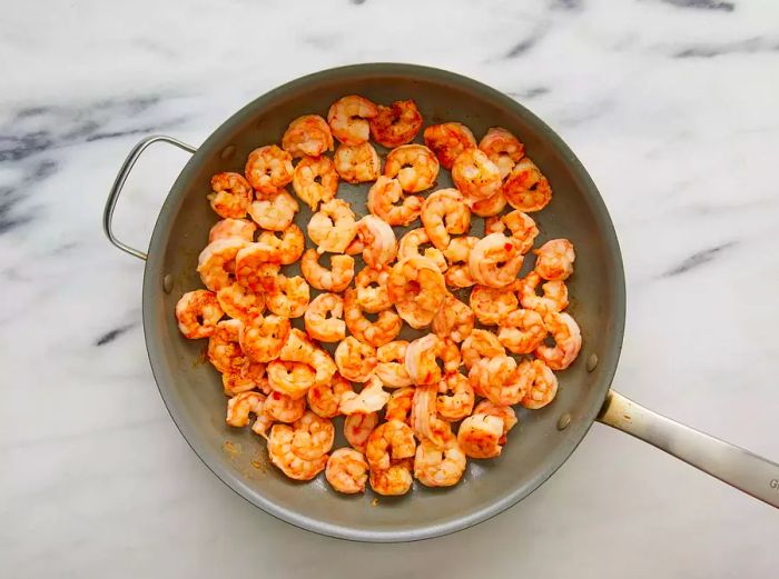 Shrimp sizzling in a hot skillet of oil.