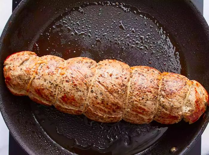 Sear the tenderloin in a large skillet until it is golden-brown on all sides.