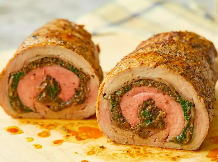 A close-up view of a stuffed pork tenderloin, sliced in half to reveal the delicious layers inside.