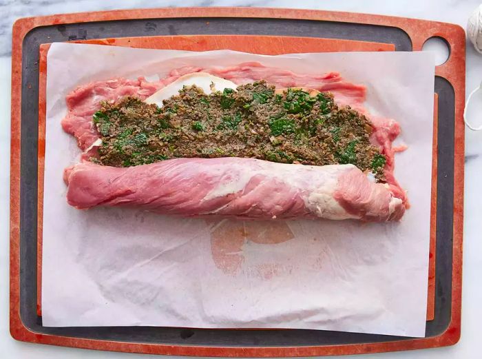 The tenderloin is rolled tightly around the filling.