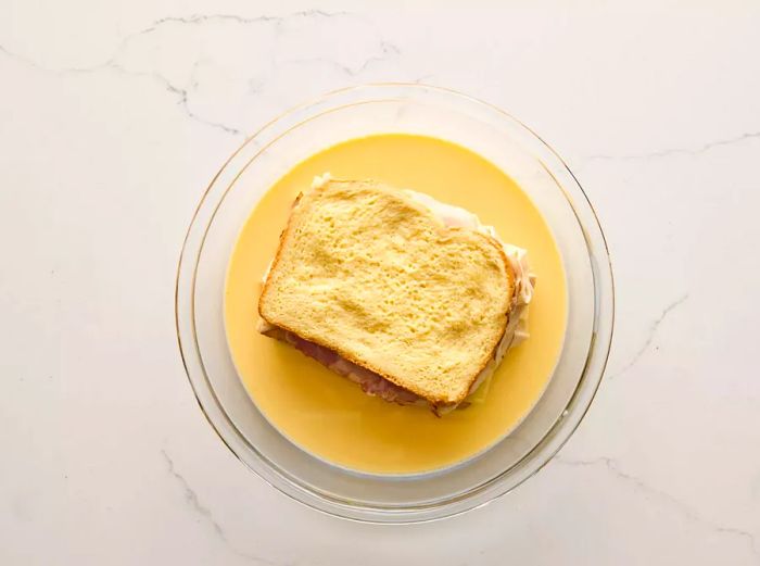 A sandwich soaking in the egg and milk mixture.